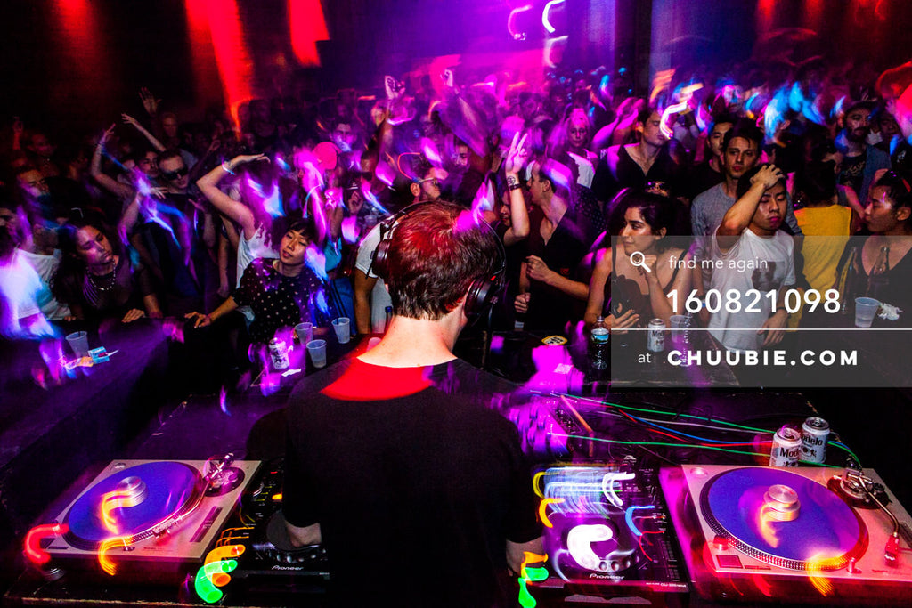 160821098 | 
Ben UFO (Ben Thomson) DJing to a packed dance floor, arms and hands up, vibrant motion / light t... | Team Chuubie