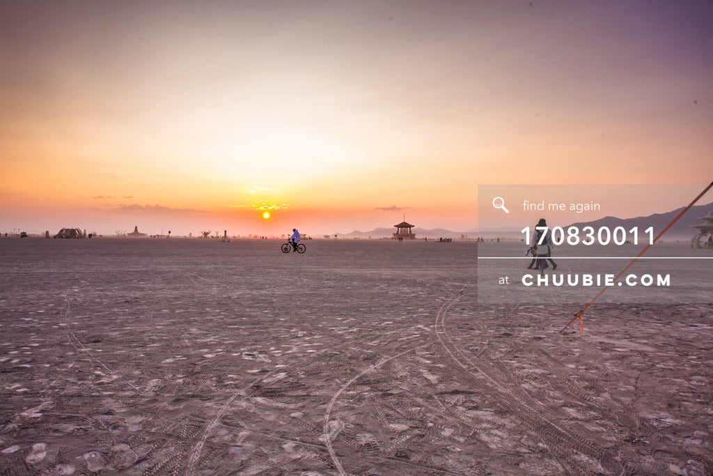 170830011 | 
Burning Man 2017 playa sunrise - quiet Wednesday morning with a burner biking in the distance an... | Team Chuubie