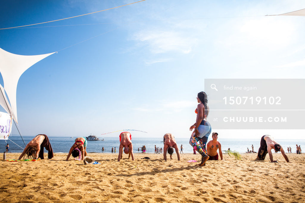 150719102 | 
Downward facing dog at beach yoga session.
—Gratitude Migration 2015: Summer Dream. Morning Glor... | Team Chuubie