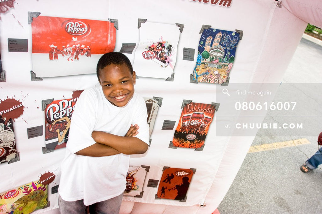 80613007 | 
Smiling young boy in front of the Sabrosura art contest winning pieces.

—Dr. Pepper Sabrosura m... | Team Chuubie