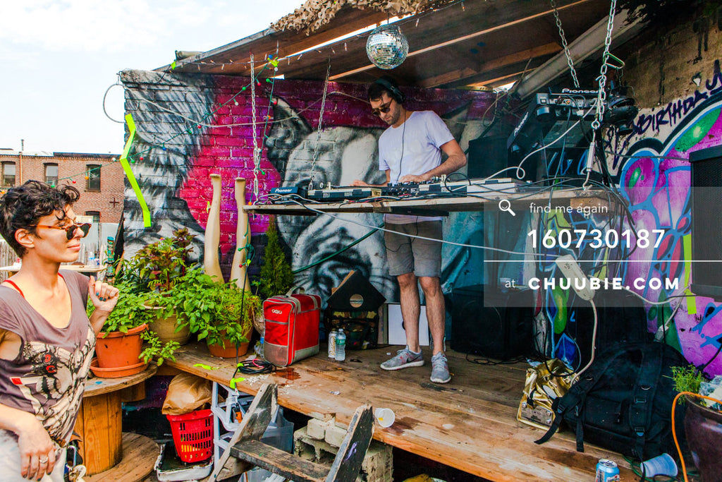 160730187 | DJ Faso (Faso) behind the decks; disco ball graffiti wall. Brooklyn summer rooftop party.
— Subli... | Team Chuubie