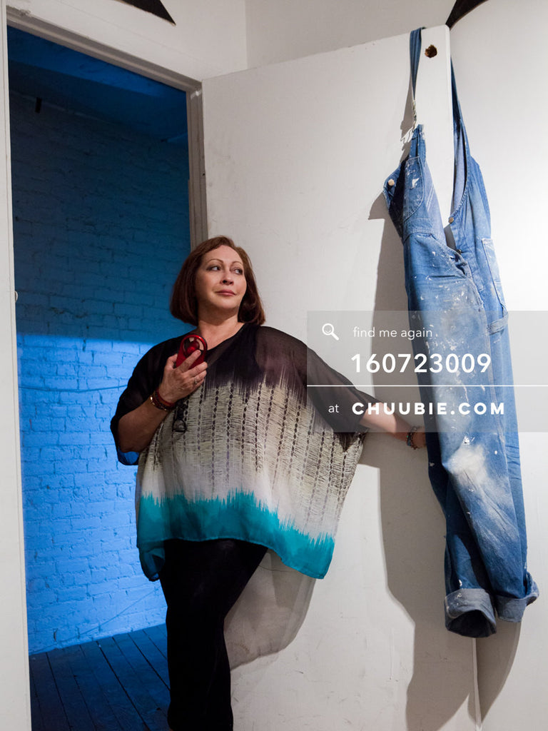 160723009 | 
Actress Tamara Torres, blue jean overalls hung on door, blue light fills the hallway in the back... | Team Chuubie