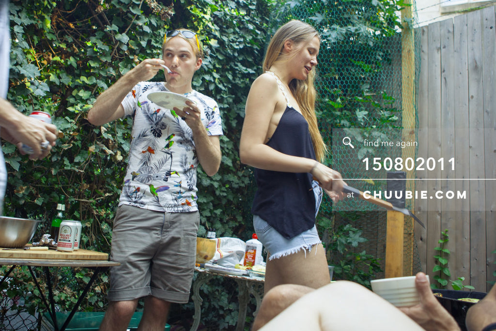 150802011 | Peter Coles in mid-bite while Lisa is at the grill in this summer backyard BBQ scene at beautiful... | Team Chuubie